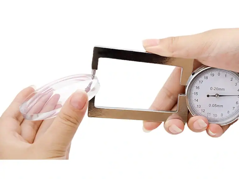 Contact thickness gauge measuring a transparent optical component